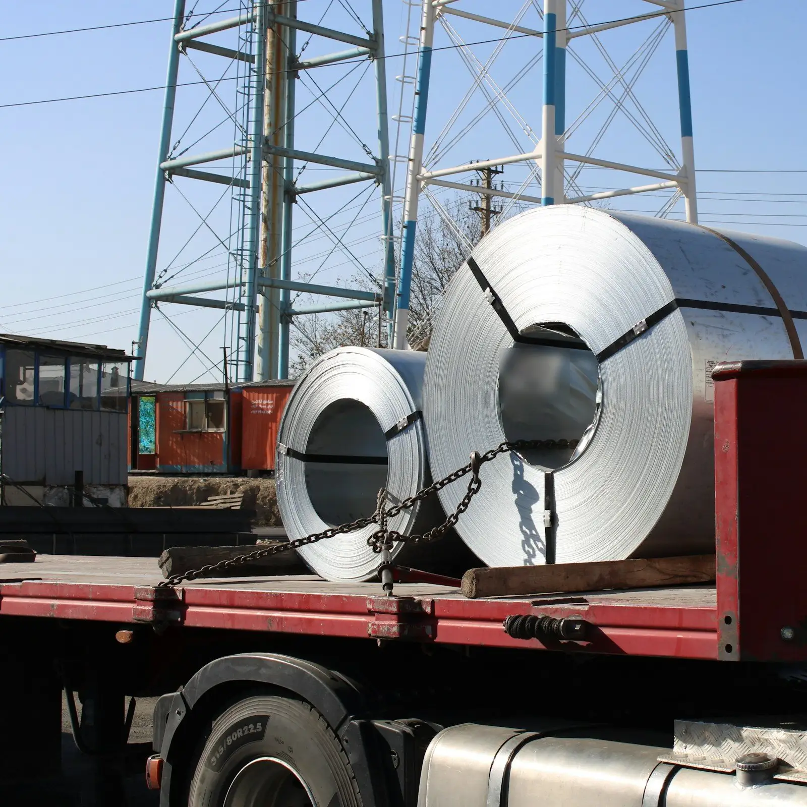 Two steel coils chained down on the flatbed of a truck.