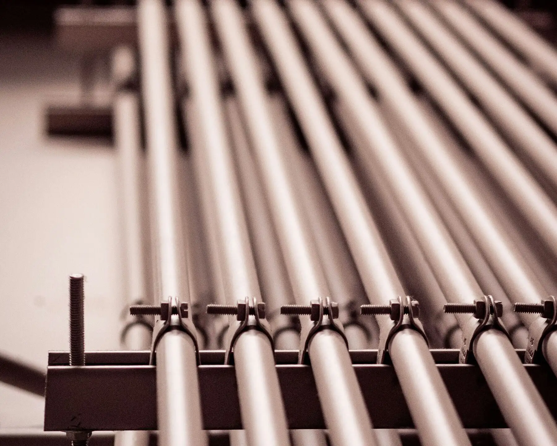 Rows of finished round pipes held in clamps on a rack, receding into the distance.