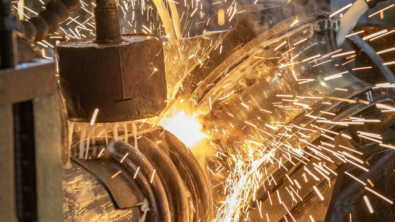 Sparks bursting from the weld point of a tube mill as the pipe passes between the squeeze rolls.